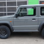grauer neuer SUZUKI Jimny Automatik mit HILLTIP SnowStriker 185 SP Schneeschild und HILLTIP IceStriker 120 bereit für den Winterdienst